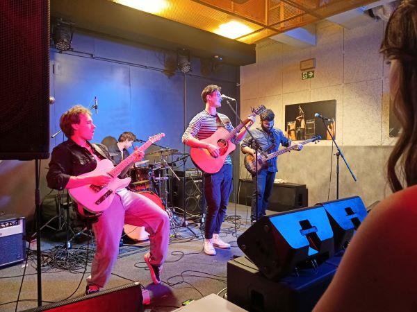 Band of 4 guys singing and dancing