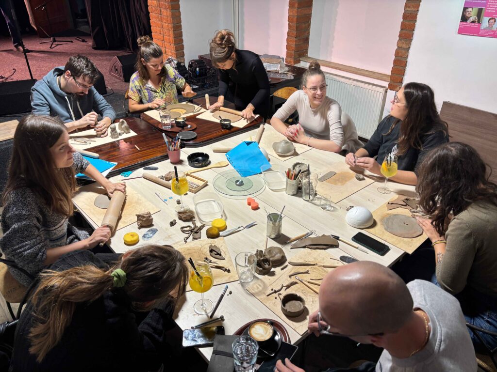 Mladi ustvarjalci med oblikovanjem glinenih izdelkov.