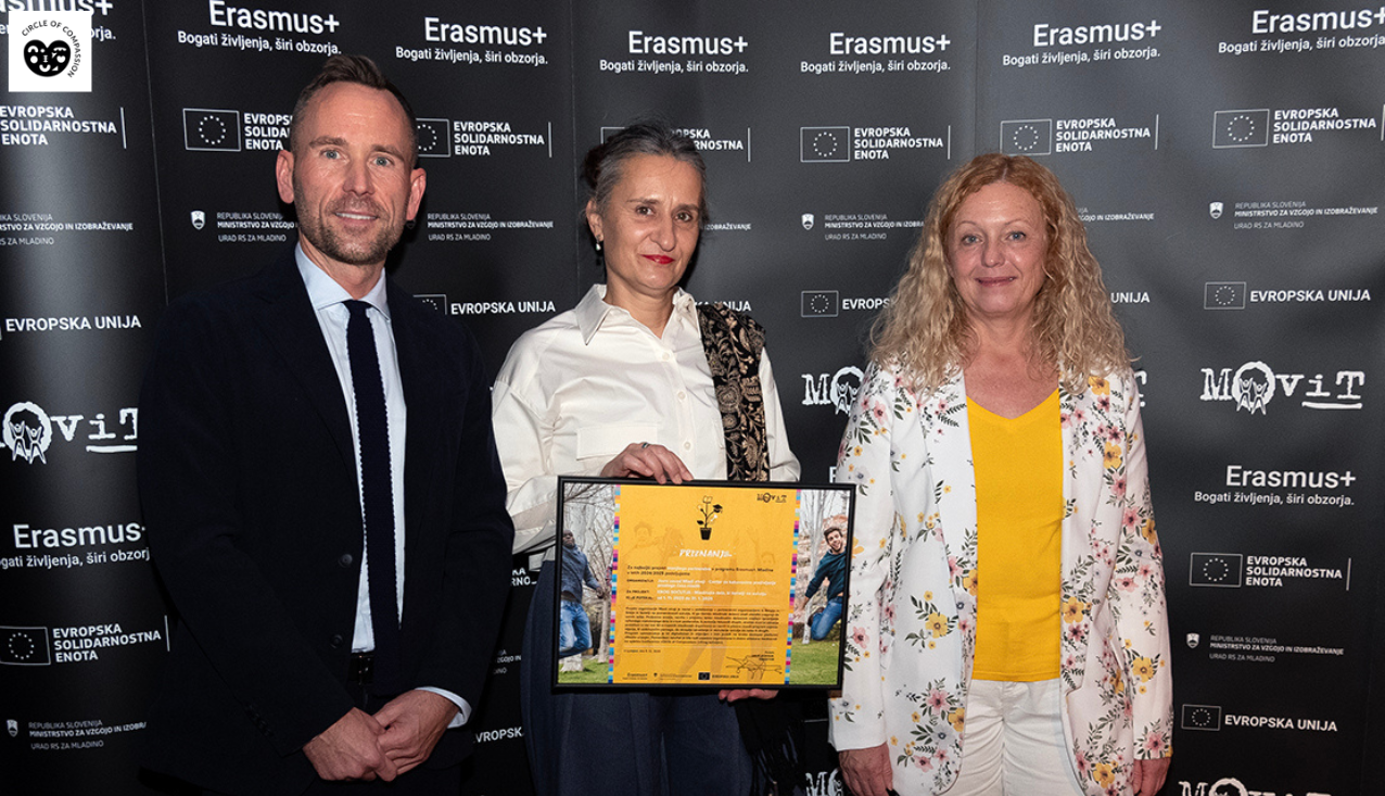 Direktorica Mladih zmajev Ksenja Perko drži uokvirjeno priznanje, ob njej stojita direktor nacionalne agencije MOVIT in mag. Tina Kosi, direktorica Urada Republike Slovenije za mladino.