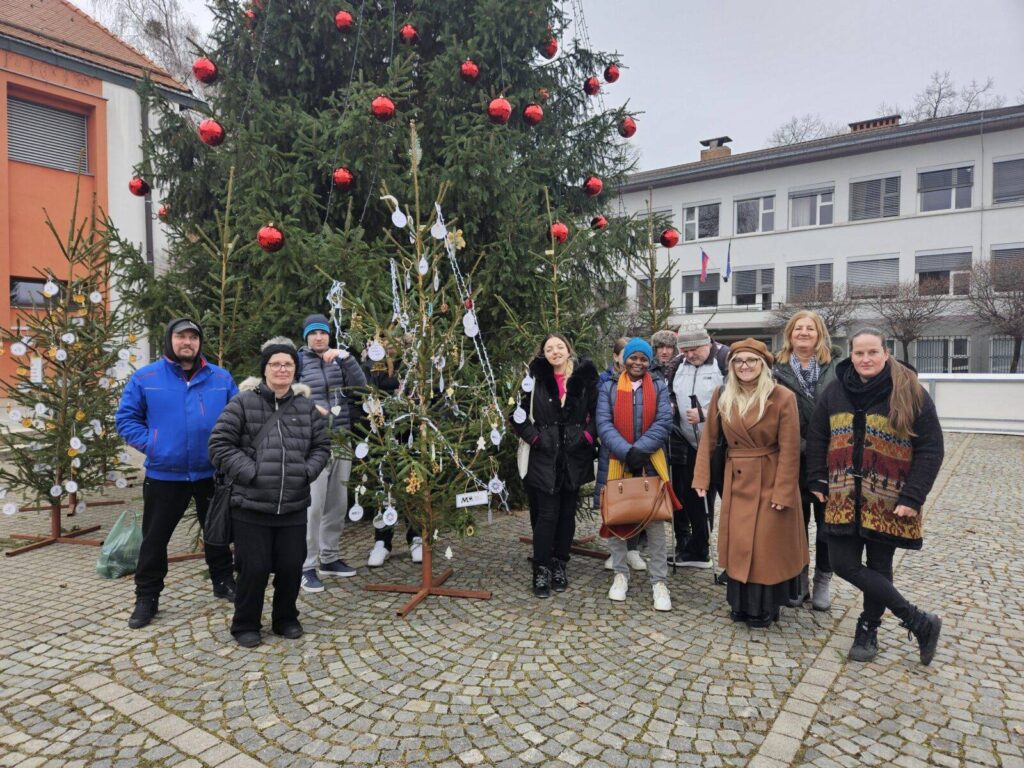 Udeleženci tretje skupine socialne aktivacije ob smrečici, ki so jo skupaj okrasili.