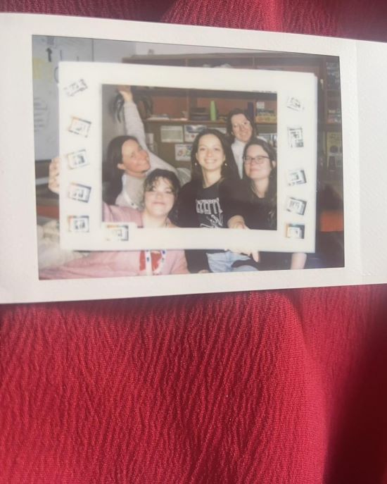 5 oseb, ki pozira pred foto okvirjem