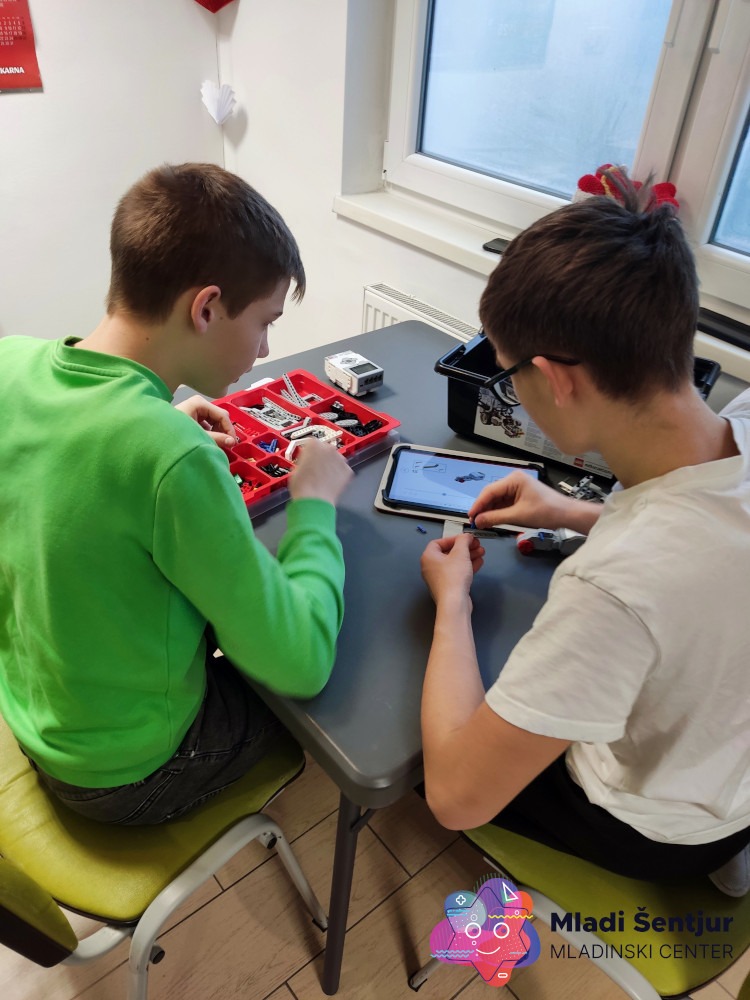 Mladi pri spoznavanju Lego robotike.