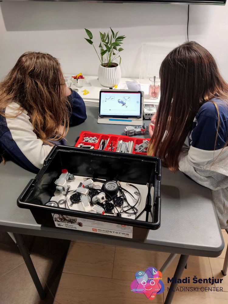 Mladi pri spoznavanju Lego robotike.