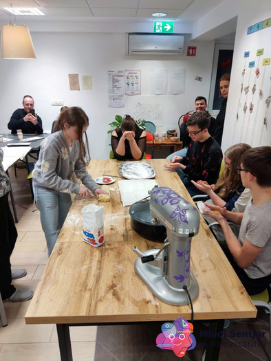 Mladi Šentjurčani izdelujejo kroglice iz testa za krofe.